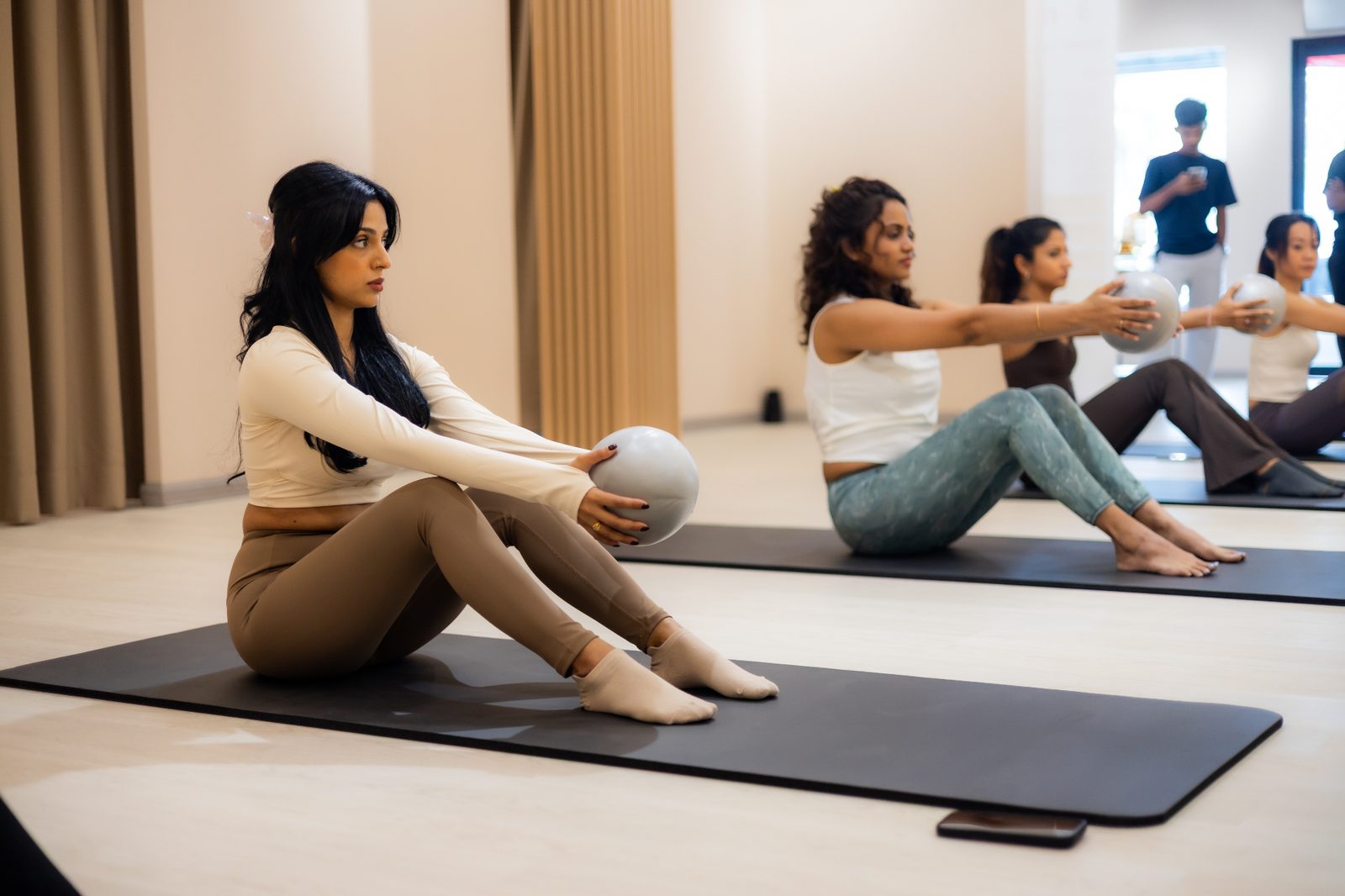 Members in a mat pilates class holding toning balls in the Bonesio studio